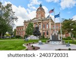 Elkhart County courthouse under cloudy blue sky and memorial with flags, law and order, Indiana