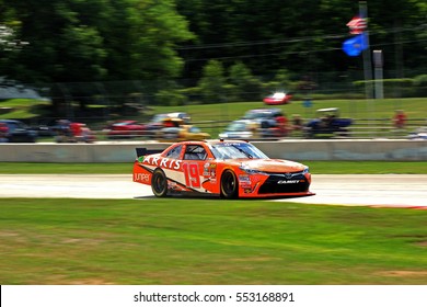 Elkhart Lake Wisconsin USA - August 26, 2016: NASCAR Xfinity racing series. Road America 180 Fired Up by Johnsonville. 19 Daniel Suarez Juniper Networks Toyota Camry, enters corner. Joe Gibbs Racing