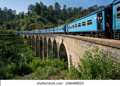 Ella / Sri Lanka - July 31, 2019: Famous Ella blue train going across the Nine Arches Bridge with passengers visible