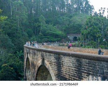 Ella, Sri Lanka - March 9, 2022: View of the nine-arch bridge, a famous place in Demodara. Tourists walk along the bridge and take pictures.