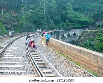 Ella, Sri Lanka - March 9, 2022: View of the nine-arch bridge, a famous place in Demodara. Tourists walk along the railway tracks on the bridge and take pictures.