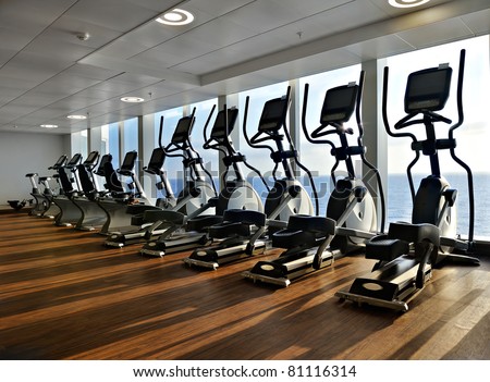 elliptical cross trainer in a row in a gym on a cruise liner with a view to the ocean