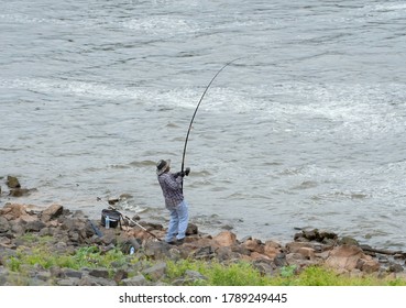 ELM GROVE, LA., U.S.A. - July 5, 2020: A Fisherman Reels In His Catch In The Waters Of The Red River In Bossier Parish, Near Elm Grove, La., U.S.A.
