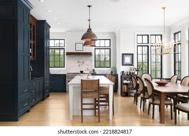 ELMHURST, IL, USA - FEBRUARY 24, 2021: A Luxurious Kitchen With Blue Cabinets, Bronze Dome Light Fixtures Hanging Above The Large White Island, And Luxury Appliances.