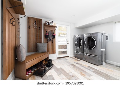 ELMHURST, IL, USA - JANUARY 15, 2021: A Renovated Laundry Room And Mud Room With Whirlpool Washer And Dryer, Tile Flooring, And Coat Hooks Mounted On The Wall.