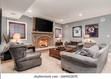 ELMHURST, IL, USA - JANUARY 30, 2020: A Man Cave, Living Room With A Television Mounted Above A Lit Fireplace And Football Jerseys Mounted On The Wall.