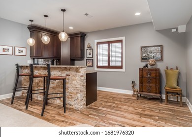 ELMHURST, IL, USA - JANUARY 30, 2020: A Basement Wet Bar With Barstools, Granite Counter Top And Dark Wood Cabinets.