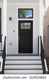 ELMHURST, IL, USA - JUNE 16, 2021: Front Door And Porch Of A White Modern Farmhouse With A Black Front Door And Railings.