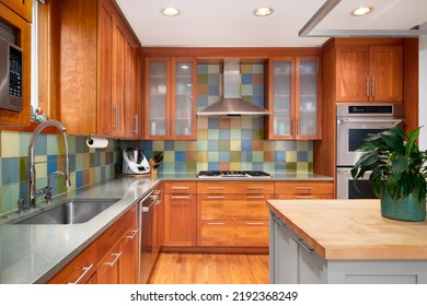 ELMHURST, IL, USA - MAY 1, 2022: A Kitchen With Wood Cabinets, Stainless Steel Appliances, And Colorful Square Tile Backsplash.