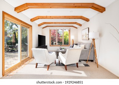 ELMHURST, IL, USA - NOVEMBER 9, 2020: A Modern Farmhouse Living Room With Wood Beams Across The Ceiling, A Sliding Door And Windows, And Furniture.