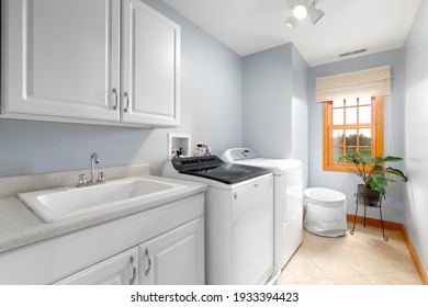 ELMHURST, IL, USA - OCTOBER 15, 2020: A Renovated Laundry Room With A White Utility Sink On White Cabinets, Tiled Floor, And New Whirlpool Washer And Dryer.