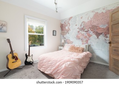 ELMHURST, IL, USA - OCTOBER 2, 2020: A Cozy Girls Bedroom With Pink Bedding In Front Of Map Wallpaper And An Acoustic And Electric Guitar.