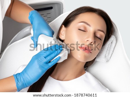 Elos epilation hair removal procedure on the face of a woman. Beautician doing laser rejuvenation on the neck in a beauty salon. Facial skin care. Hardware ipl cosmetology