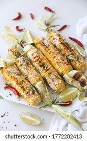 Elotes, Grilled Mexican Street Corn, Summer, BBQ , Fast, Healthy Food Concept, Top View, Flat Lay, White Background, Decorated With Red Hot Chili Peppers Lime And Cilantro Leaves