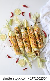 Elotes, Grilled Mexican Street Corn, Summer, BBQ , Fast, Healthy Food Concept, Top View, Flat Lay, White Background, Decorated With Red Hot Chili Peppers Lime And Cilantro Leaves