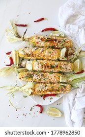 Elotes, Grilled Mexican Street Corn, Summer, BBQ , Fast, Healthy Food Concept, Top View, Flat Lay, White Background, Decorated With Red Hot Chili Peppers Lime And Cilantro Leaves