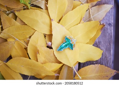 Elven Lorien brooch lies on a yellow leaves carpet