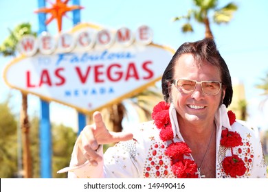 Elvis Impersonator Man In Front Of Las Vegas On The Strip Pointing Looking At Camera. People Having Fun And Viva Las Vegas Concept With Elvis Look-alike