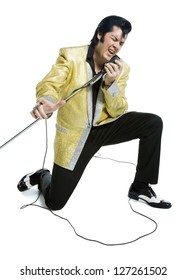 An Elvis Impersonator Singing Into A Microphone