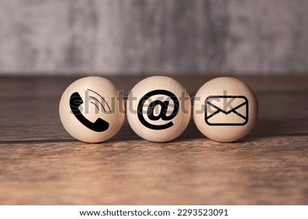 E-mail address ,telephone number and letter icons print screen on circle wooden block on table for webpage business contact and customer service concept.