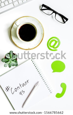 e-mail contact us concept with internet icons and glasses work desk background top view