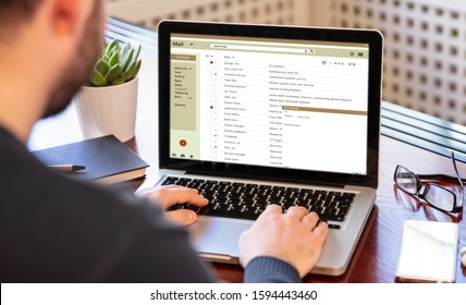 Email Inbox Message List On A Computer Laptop Screen, Man Working On An Office Desk, Business Background. E-mail Correspondence Mail Concept