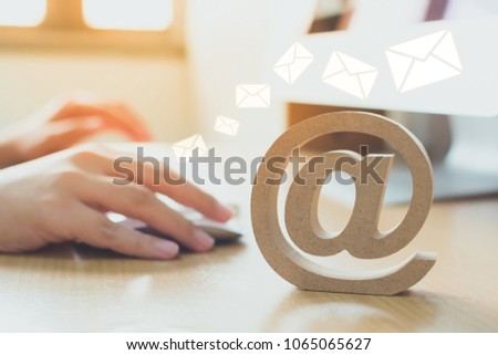 Email marketing concept, Hand using computer sending message with wooden email address symbol and envelope icon