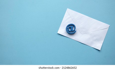 Email Marketing Concept. A White Envelope And Email Address Symbol On Blue Background With Copy Space.