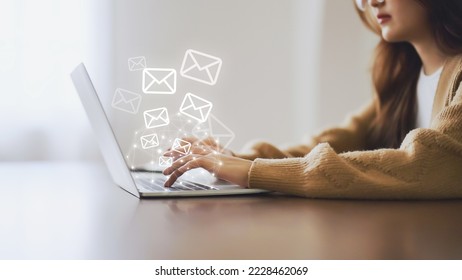 Email marketing and newsletter concept. Woman using computer laptop and sending online message with email icon - Shutterstock ID 2228462069