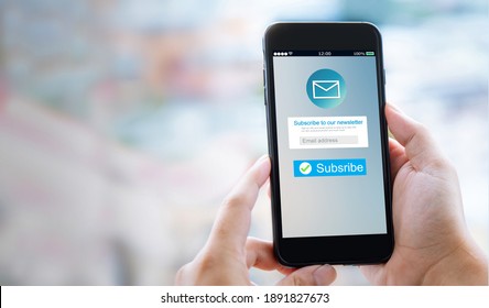 Email marketing subscribe our newsletter concept.Female hands using mobile phone with copyspace - Shutterstock ID 1891827673