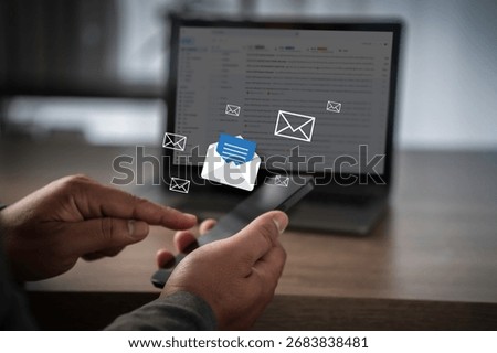 Email message concept: hands using smartphone before a laptop inbox, floating envelope icons, mailing contacts, new notifications, mobile communication for business, marketing, remote productivity.