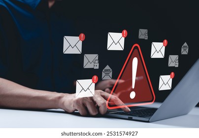 Email security warning notification concept. A person using laptop with email security alert icons and warning notifications, indicating cybersecurity threats such as spam, viruses, junk mail, scams, - Powered by Shutterstock