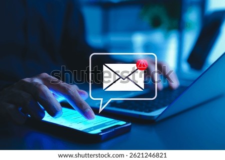 Email security warning notification concept. A person using a smartphone with email security alert icons and warning notifications, indicating cybersecurity threats, spam, virus, junk mail, and scams.