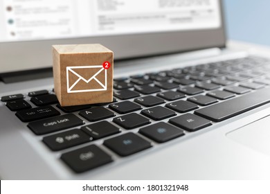 Email symbol on wooden block showing new message on laptop keyboard
