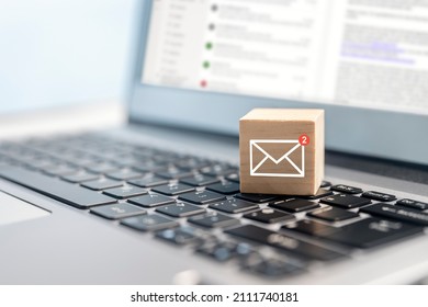 Email symbol on wooden block showing new message on laptop keyboard - Shutterstock ID 2111740181