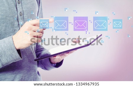 Emails with man holding a tablet computer