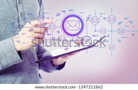 Emails with man holding a tablet computer