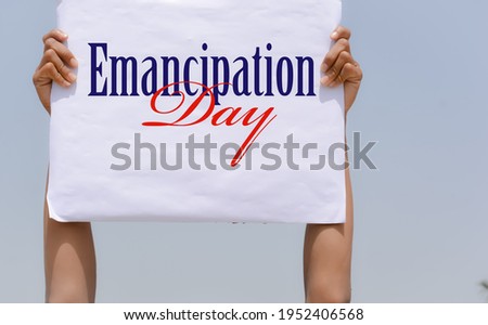 Emancipation Day banner in hand in sky background