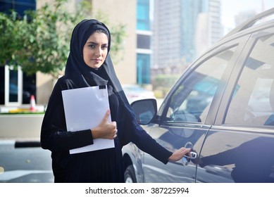 Emarati Arab Business Woman Getting Inside The Car In Dubai, United Arab Emirates.