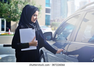 Emarati Arab Business Woman Getting Inside The Car In Dubai, United Arab Emirates.