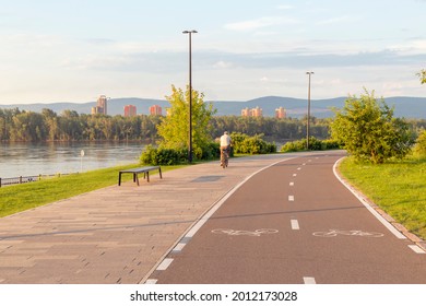 Embankment In The City In Summer With A Bike Path And Green Spaces. Urban Environment, Public Space.