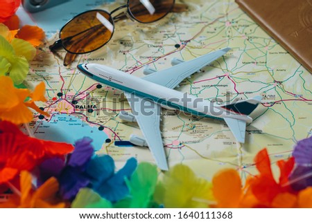 Embark on an adventure. Map, plane, camera, glasses and passport on the table. Travel, vacation concept.