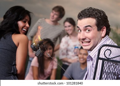 Embarrassed Man With Burning Marshmallows At A Cookout