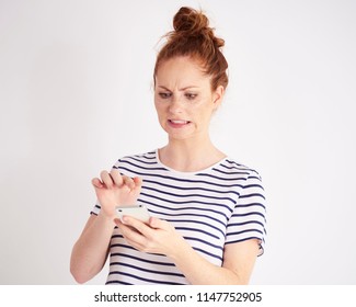 Embarrassed Woman Using A Mobile Phone At Studio Shot 