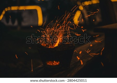Ember spark fire forge heat metal glow workshop industrial blacksmith, orange ember and flying spark burst from hot forge vessel dark workshop during metal craft work with intense heat