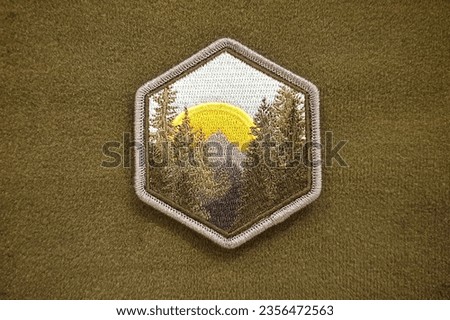 The emblem of the sun rising in the middle of the forest, morale patch, is a velcro patch used for attaching to clothing and bags.
