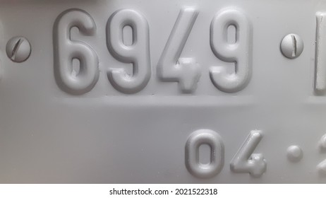 Embossed Numbers Listed On The License Plate Of A Motorized Vehicle