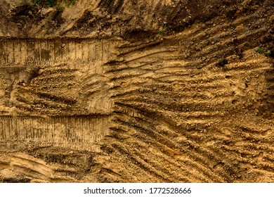 Embossed Trail Excavator Tracks On The Wet Sand.