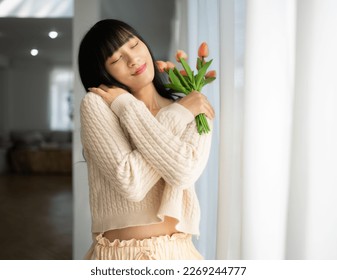 Embrace equity on multiracial Internal Women's Day. Asian lady good mood hands hug herself shoulders enjoy joyful warmth toothy smile.