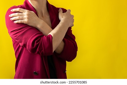 Embrace equity. Woman hug yourself dressed magenta jacket on yellow background. International women's day concept. Vivid colors, copy space